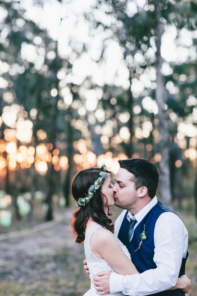 Bride and groom kissing during sunset photo session at Gunyah Valley wedding.