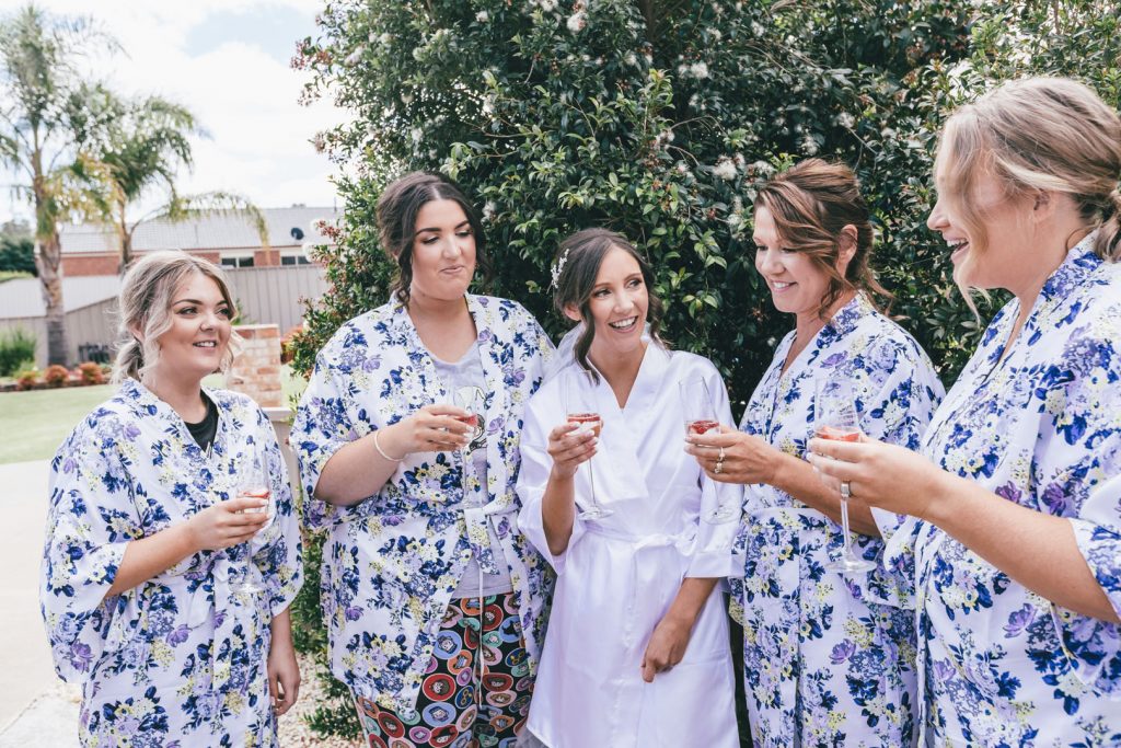 Bride and bridesmaids in robes toast during getting ready at Norton Estate wedding.
