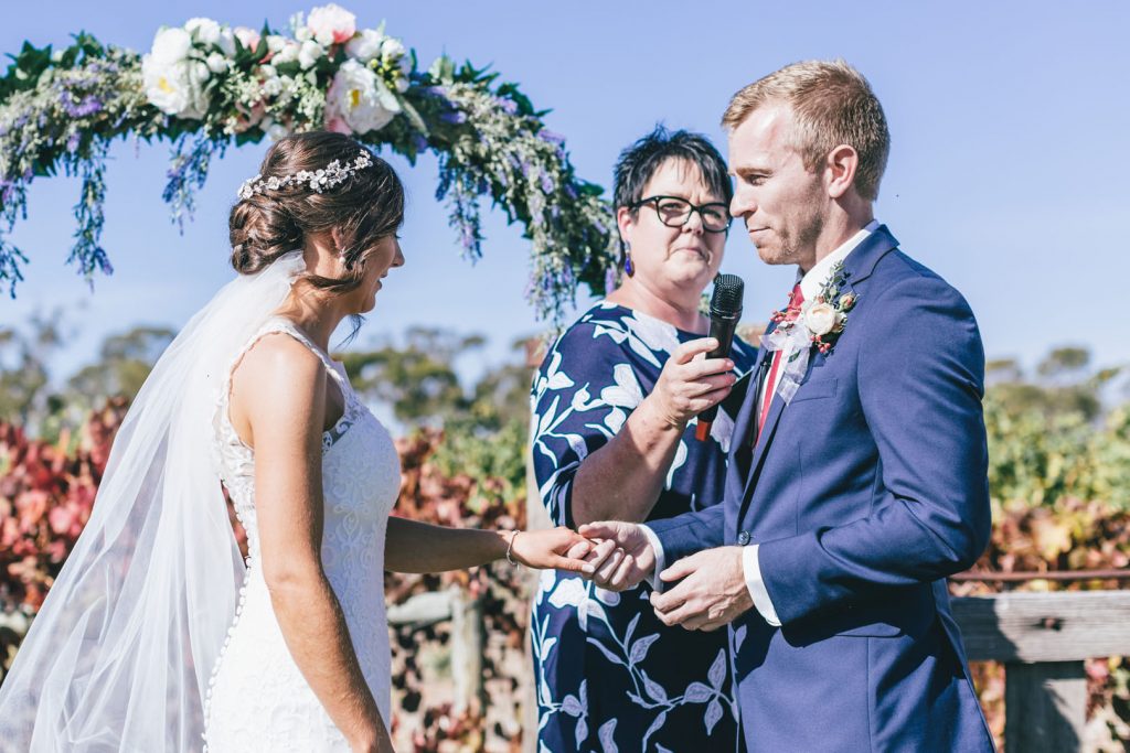 Groom putting ring into his bride at Norton Estate wedding.