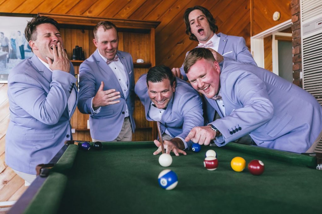 Groom and his groomsmen playing pool before wedding ceremony.