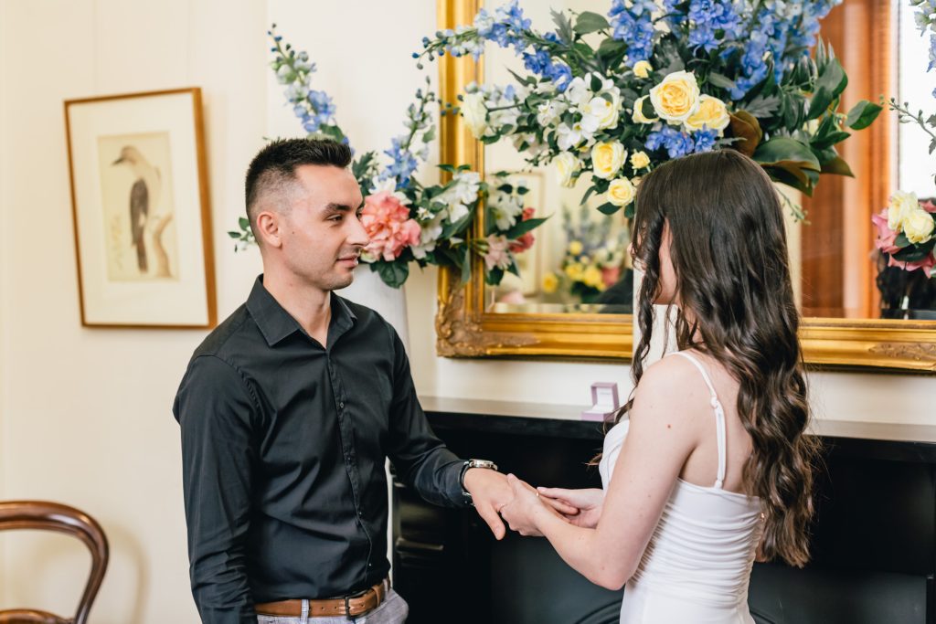 Bride put on the wedding ring on her groom during ceremony at Melbourne registry office.