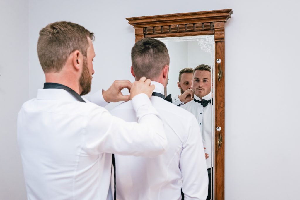 Grooms getting ready with help of the groomsmen.