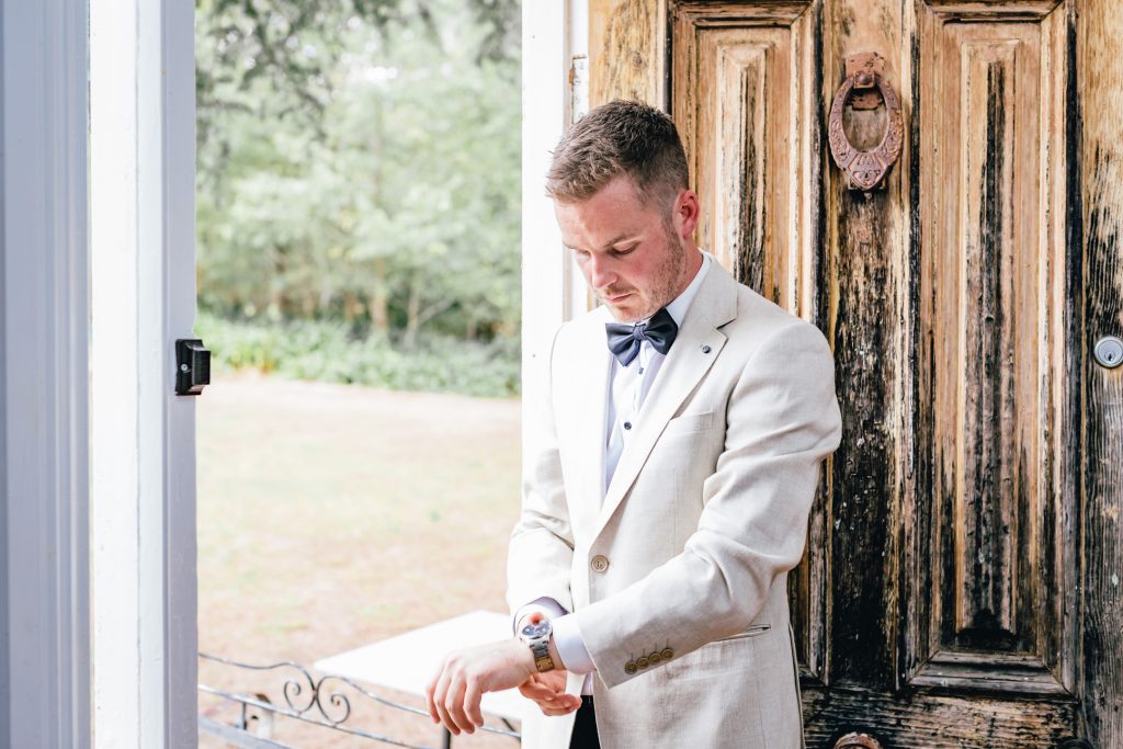 Grooms posing with watch at Ravenswood Homestead.