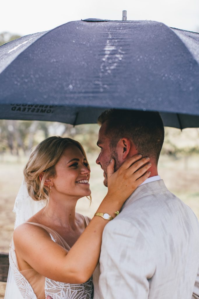 Bride and groom photo session with umbrella at Ravenswood Homestead Wedding.