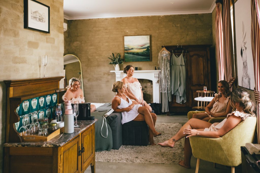 Bride and bridesmaids getting ready in robe before Ravenswood Homestead Wedding.