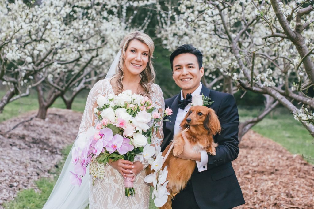 Bride and groom posing with their dog at Farm Vigano wedding.