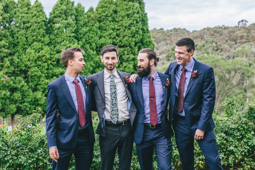 Groom and his groomsmen with arms around each other.