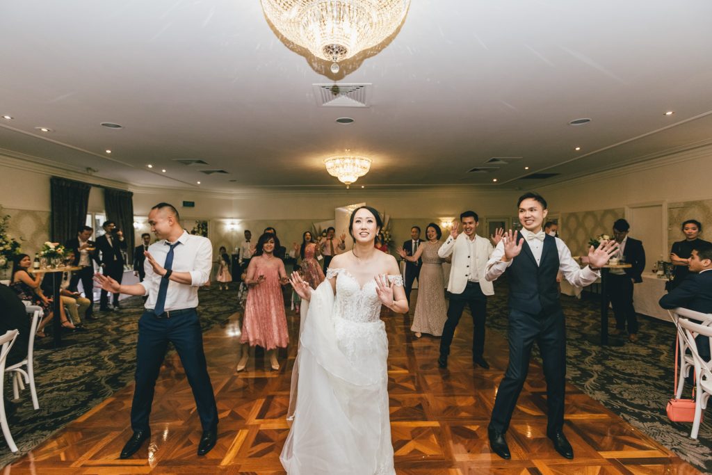 Bride dancing in a group dance with her guests at Ballara Receptions Eltham wedding.
