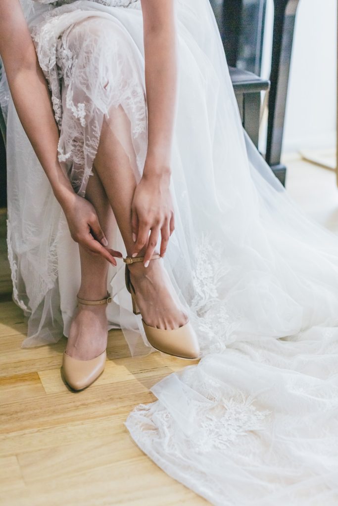 Bride wearing her wedding shoes during bride getting ready.