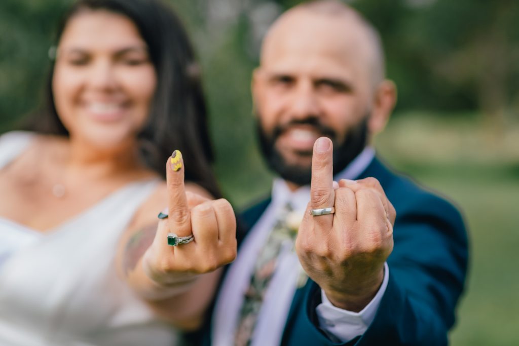 Bride and groom showing their wedding rings after wedding ceremony.