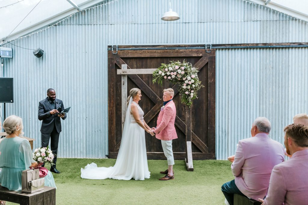 Bride and groom holding hand during wedding ceremony at Rocklea Farm wedding.