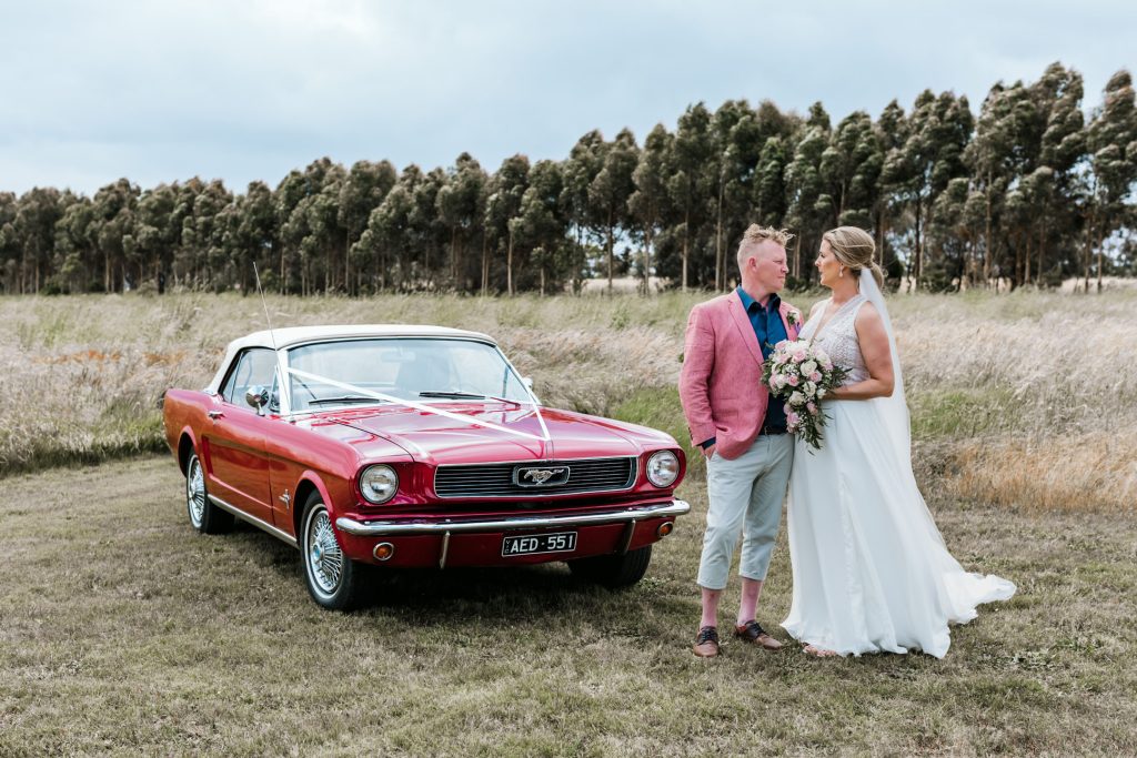 Bride and groom standing next to mustang wedding car for Rocklea Farm wedding photography.