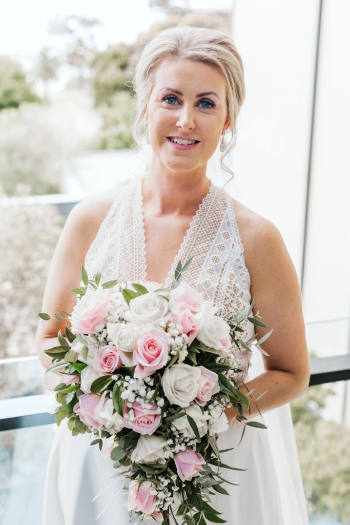 Beautiful bride with her roses bouquet of flowers.