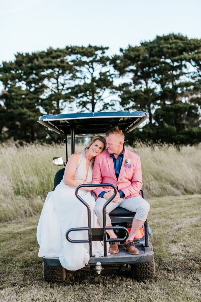 Bride and groom sitting on gold buggy after wedding reception at Rocklea Farm wedding.