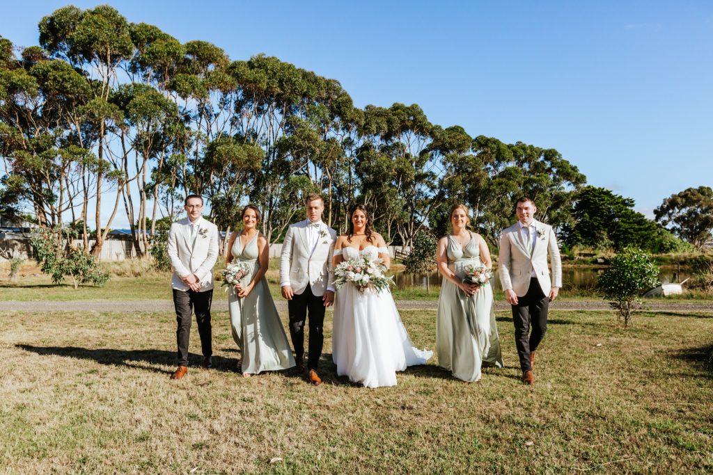 Bride and groom with their bridesmaids and groomsmen walking at Rocklea Farm Stonehaven.