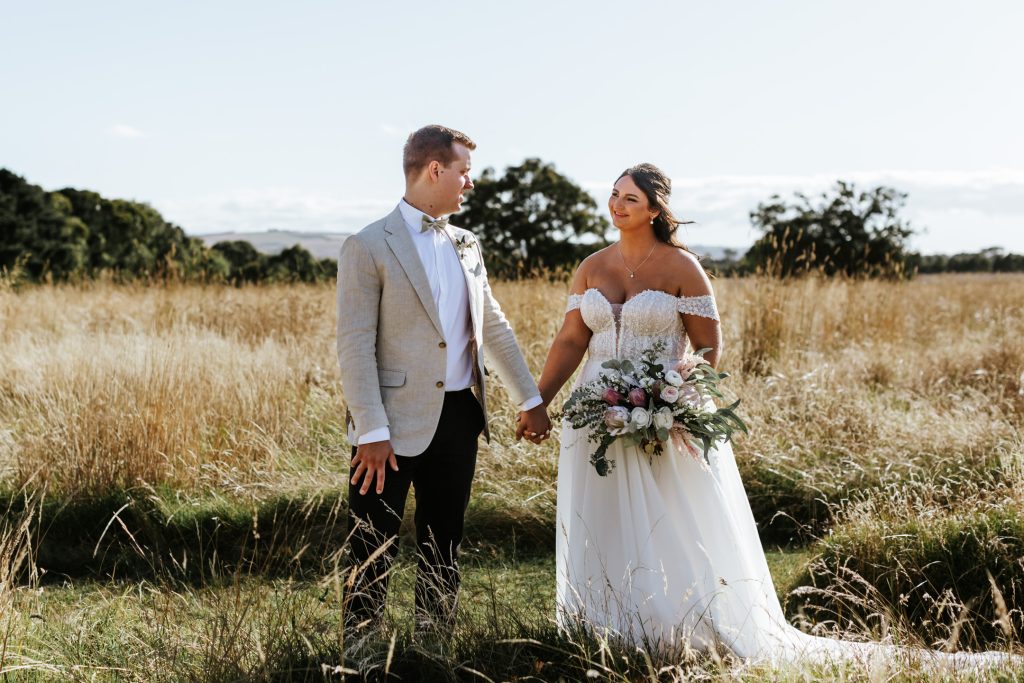 Bride and groom looking at each other lovingly while holding hands at Rocklea Farm wedding.