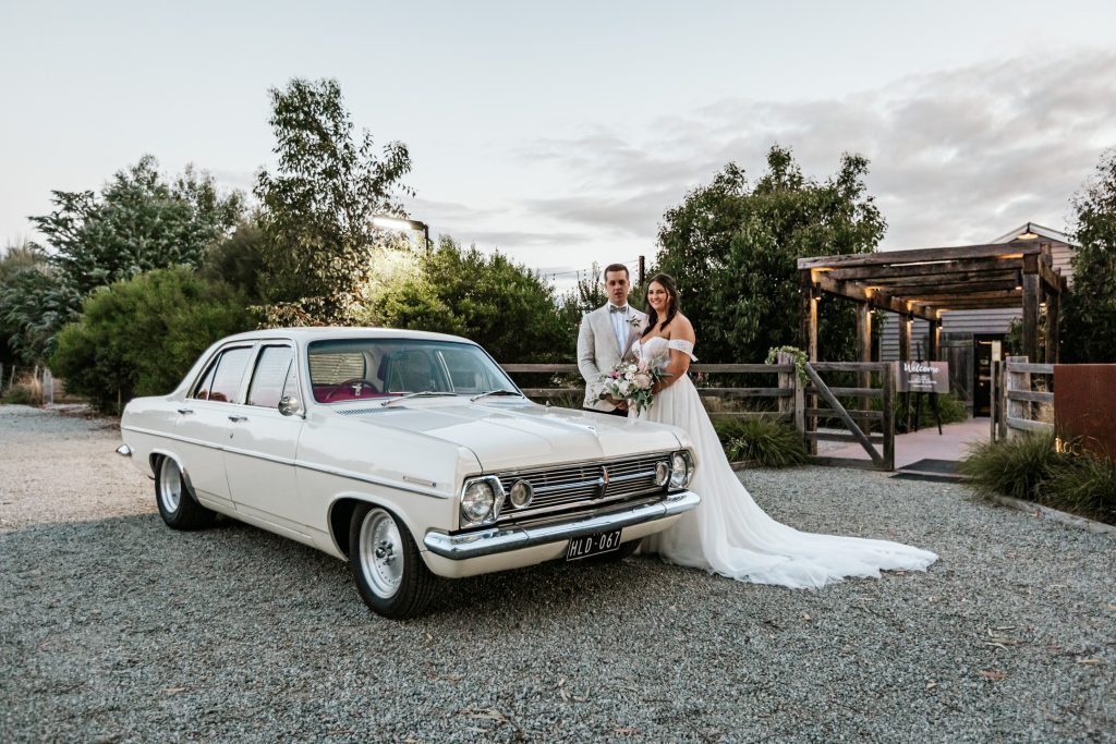 Bride and groom standing with their classic wedding car for their Rocklea Farm Stonehaven wedding.