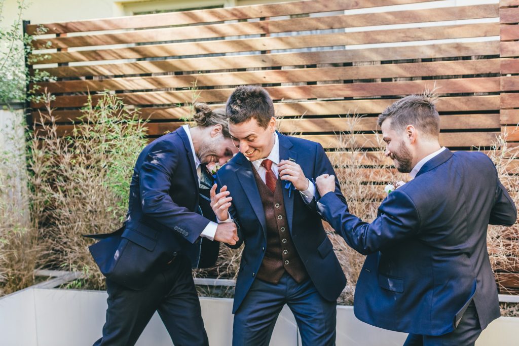 Groom and groomsmen having a great time during getting ready for his wedding day.