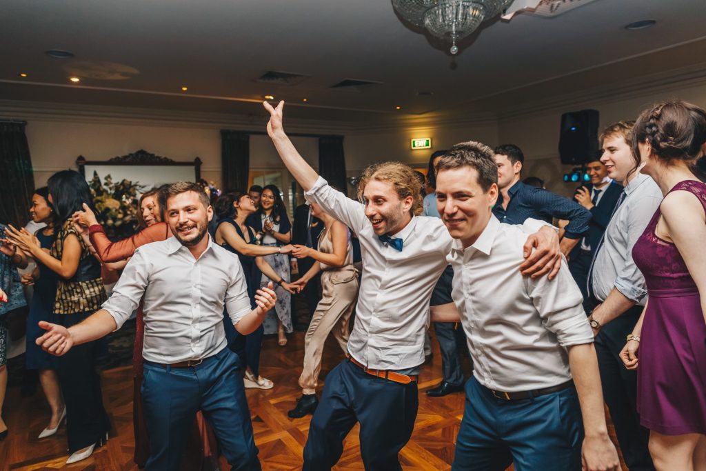 Groom and his groomsmen dancing during wedding reception.